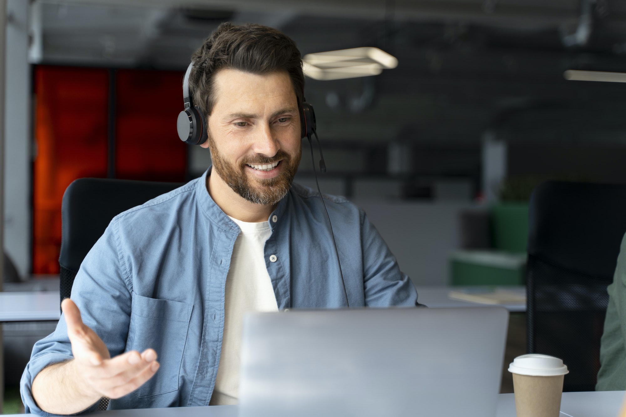 Caucasian handsome adult male HR manager in audio headset, smiling conducting online job interview